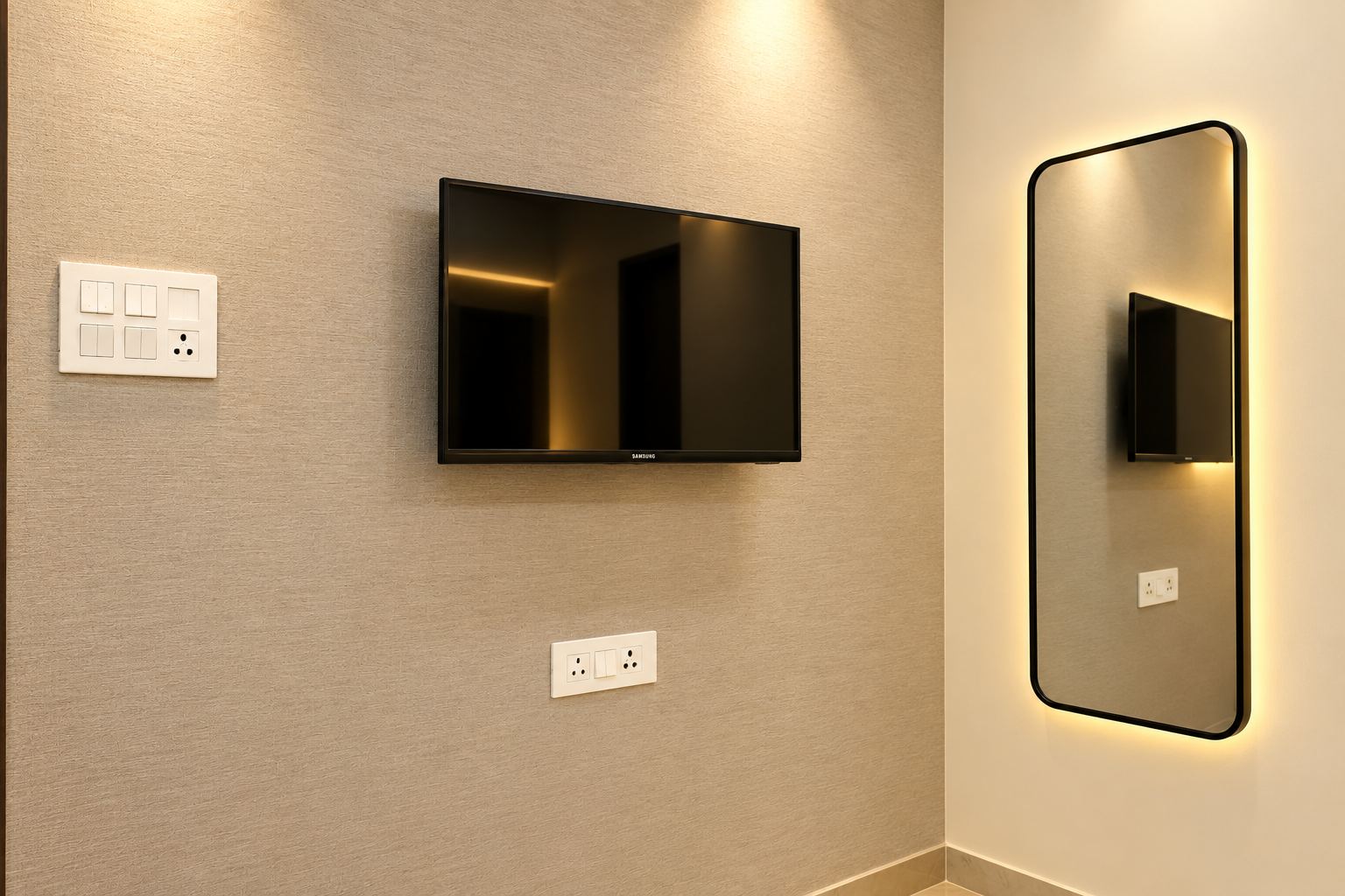 Signature Room TV and mirror wall at Hotel Rakesh Grand